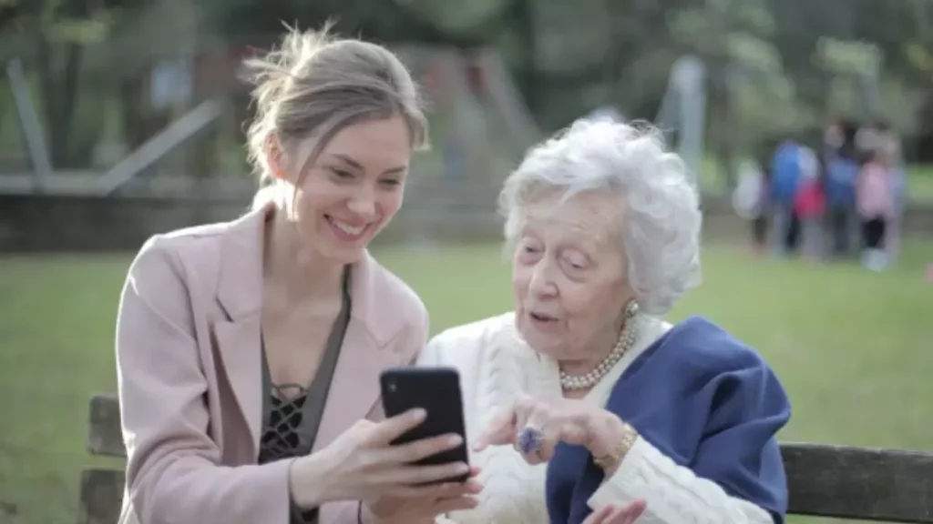 Idosa aprende a usar celular com ajuda de jovem em parque – inclusão digital na terceira idade