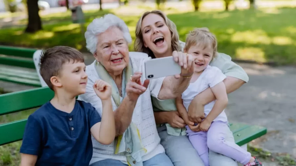 Uma idosa sorridente ao lado de seus netos — transmite afeto, vitalidade e conexão entre gerações.